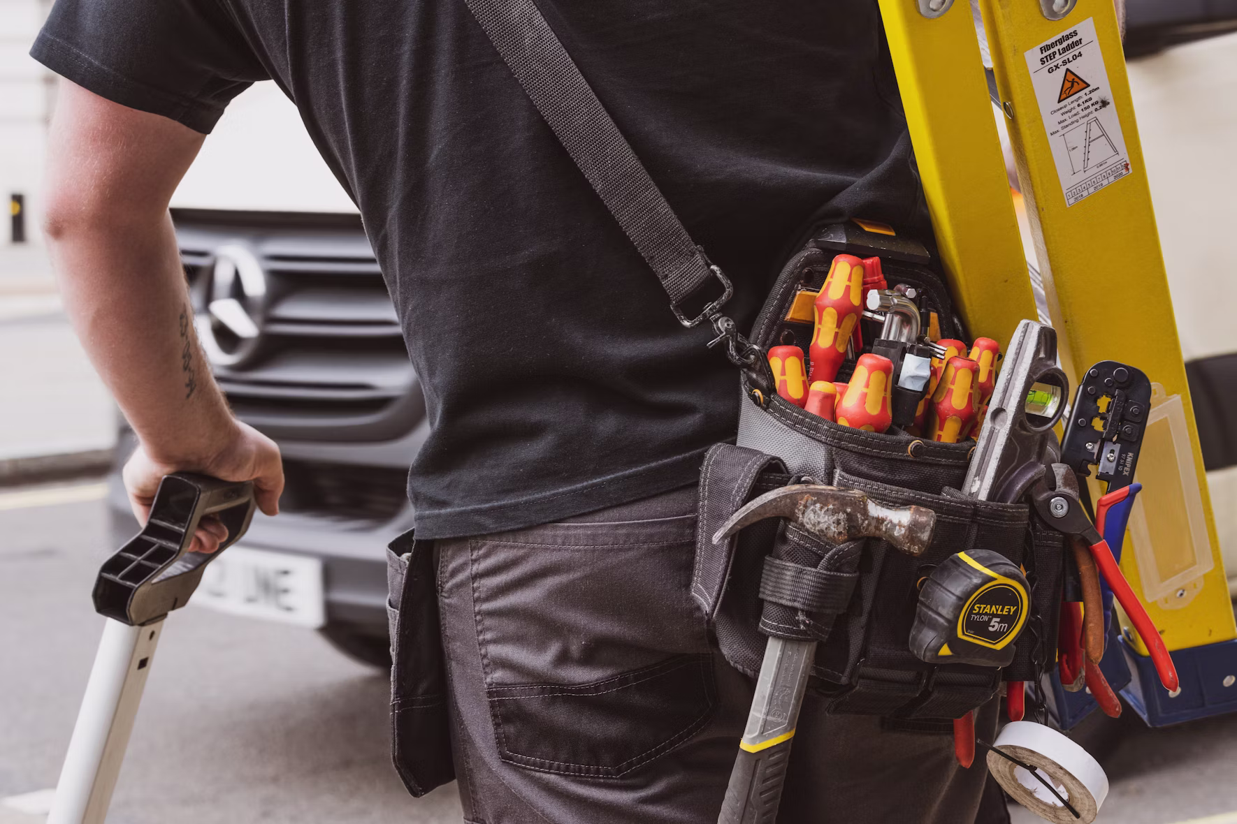 Vänlig handyman med skruvdragare i ett ljust hem